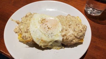 Southern Benny: Open-Faced Buttermilk Biscuit topped with shaved country ham, 1 over easy eggs, and sausage gravy