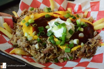Smokehouse BBQ Pork Fries - crispy, seasoned french fries piled high with slow smoked pulled pork, cheddar cheese, sweet and mild barbecue sauce, sour cream , and scallions. Hickory House