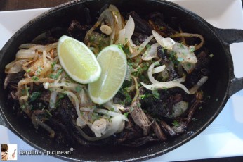 Vaca Frita (fried cow) - portion of chuck that's been braised and shredded, then fried on a flat grill, creating soft and crispy meat, with garlic and onions. Served with black beans and white rice