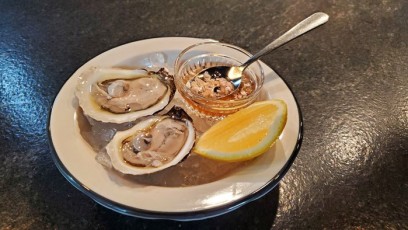 Oysters with magic Mignonette sauce - traditionally made with minced shallots,  cracked black peppercorn, and vinegar (either red or white) on top.
